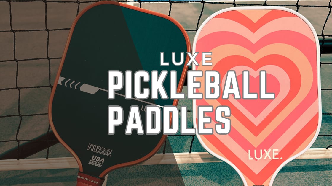 Luxe pickleball paddle reviews: 1 black finesse paddle and 1 heart paddle next to a pickleball net.