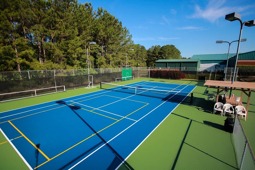 blue pickleball court with yellow and white lines representing when was pickleball invented.