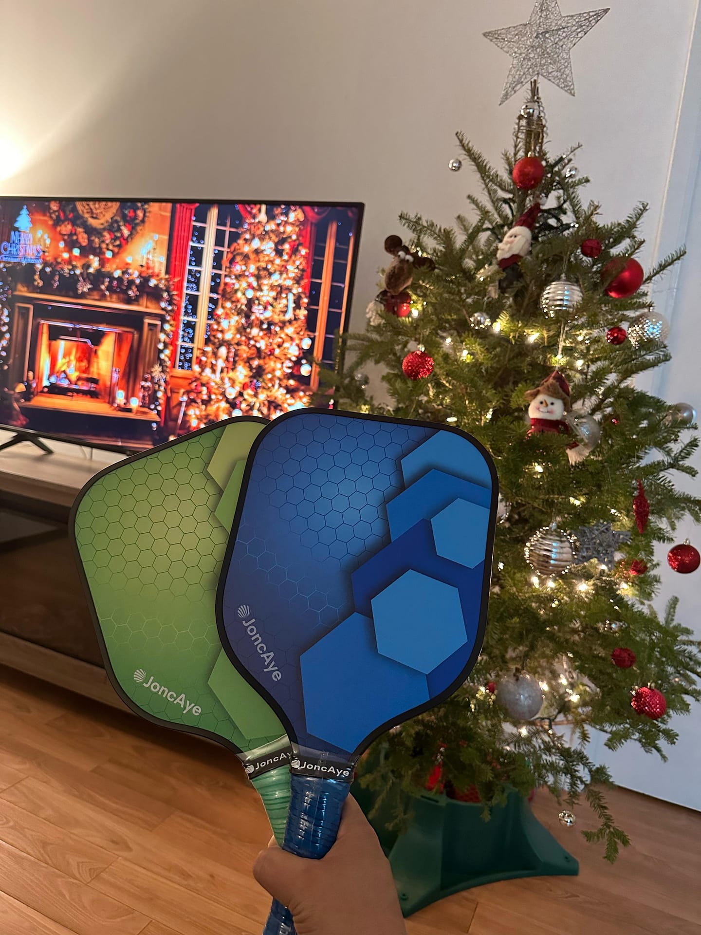 JonCaye pickleball paddless in front of pine tree showing the best pickleball christmas gifts 2023