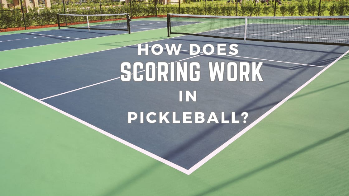 How Does Scoring Work In Pickleball? A Pickleball court in the background with blue service blocks.