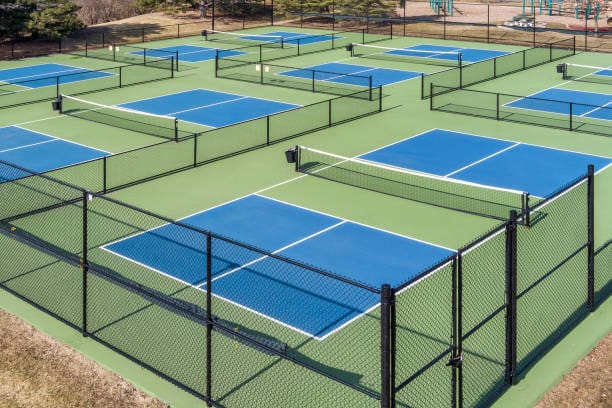 overhead photo of 8 blue pickleball courts displaying how big pickleball courts is